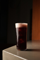 Dark Red Cocktail or Soda in Highball Glass on Concrete Bar