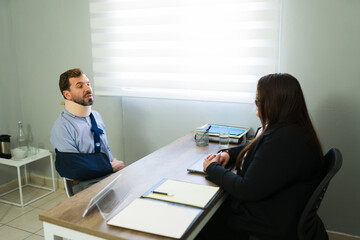 Man with neck brace discussing accident claim with lawyer
