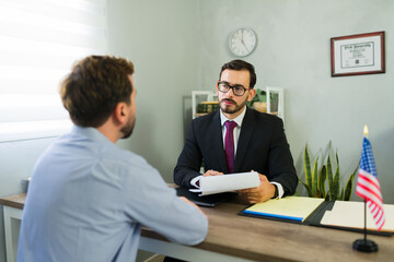 Obraz premium Male immigration lawyer advising client in law office