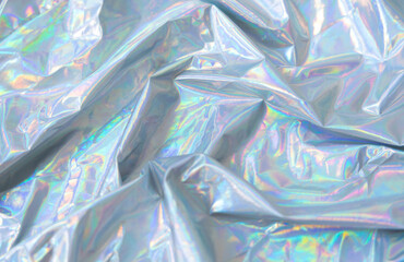 Holographic Y2K iridescent fabric background, Crumpled holographic fabric with iridescent glow in pastel tones. Trendy Y2K aesthetic background with dreamy metallic texture and soft light reflections.