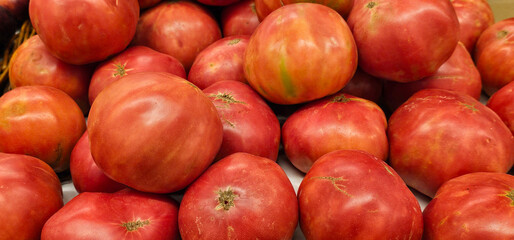Close-up of fresh pink tomatoes at a local market in Andalusia, Spain. The vibrant color and natural texture highlight their freshness. organic produce