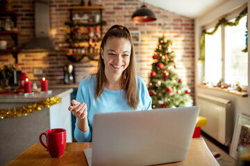 Young woman video calling at home during christmas