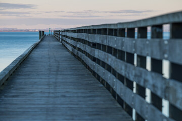 Fototapeta premium ニュージーランド オークランドの郊外にあるコーンウォリス・ビーチの夕暮れ時の桟橋の上からの風景