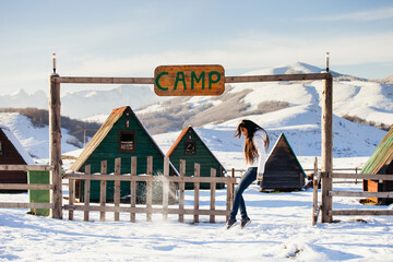 woman play with snow at ski resort camp with happy face. Winter snowy mountains background