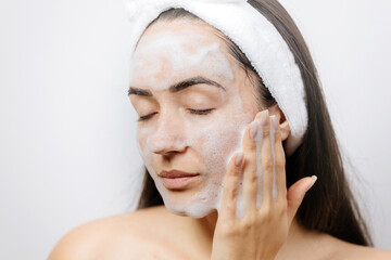 woman washing face foam. female applying Facial Cleanser. Young adult woman using foam cleanser for face skin cleaning. 