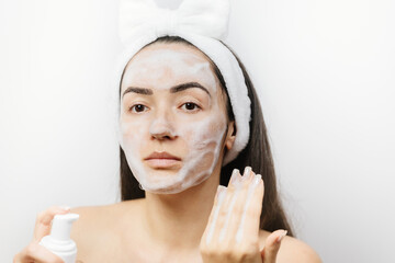 woman applying Facial Cleanser. Young adult woman using foam cleanser for face skin cleaning. 