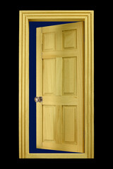 A single miniature open wooden door isolated on a black background