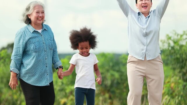 Smiling Senior Woman with kid playing near wind turbines in the background Representing Renewable Energy Eco Lifestyle and Sustainable Future