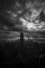 Fototapeta premium A Dark and Moody Panorama of the Iconic Manhattan Skyline Underneath a Stormy Sky