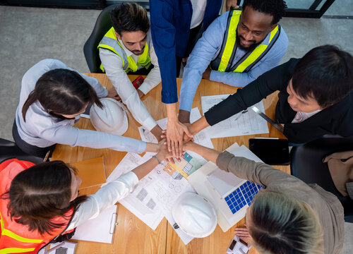 top view business people engineer joining hands motivated team building in financial meeting office, group of multiracial colleagues man and woman diverse employee coworker stacking hands together - Powered by Adobe