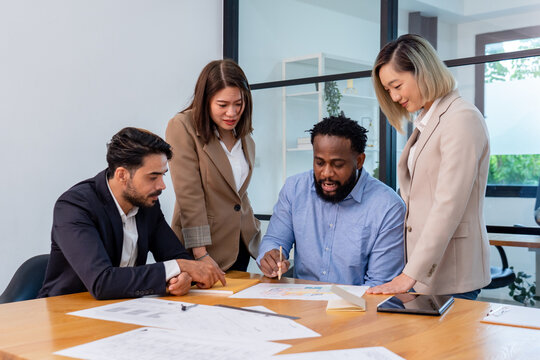 team of multiethnic coworker meeting on solar roof system project with solar panel house model, responsibility of green industry alternative renewable clean environment energy for sustainable business