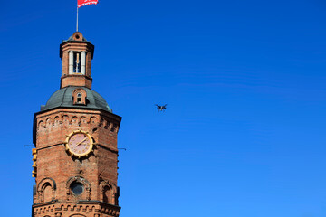 Obraz premium Small drone close to city tower
