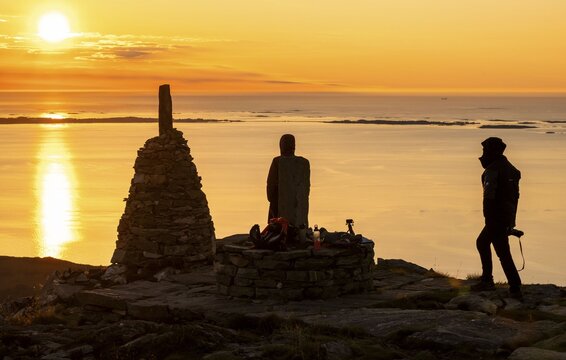 Silhouettes of two hikers next to cairns at sunset, R&oslash;rsethornet stone staircase, with 3292 steps one of the longest continuous stone staircases in the world, Sherpatreppe or Midsundtreppe or Midsundtrappene, R&oslash;rsethornet hike, Otroya or Otr&oslash;ya island, M&oslash;re og Romsdal, Norway
