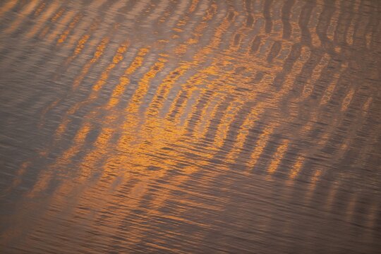 Warm sunlight reflects on gentle waves in a bay at sunset, forming a wave-like pattern, Otroya or Otr&oslash;ya Island, M&oslash;re og Romsdal, Norway