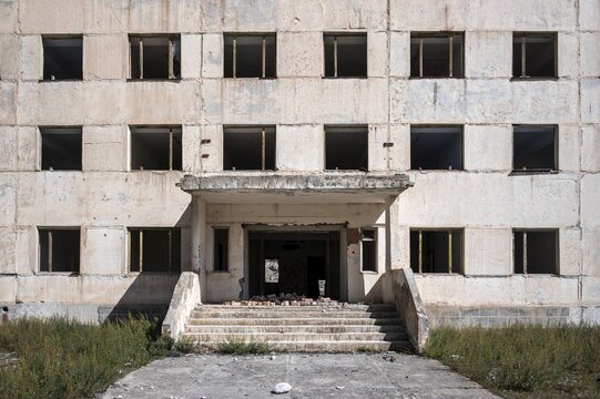 Entrance to an abandoned, destroyed residential building, old Soviet apartment blocks in the ghost town, Engilchek, Tian Shan, Kyrgyzstan