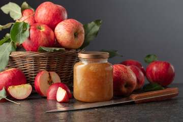 Apple jam and fresh apples with leaves.