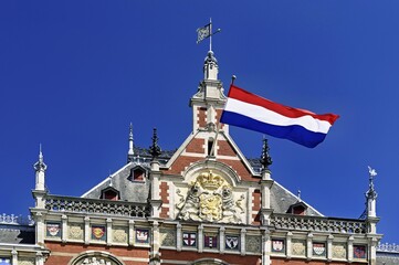 Centraal Station, Central Station with flag, Amsterdam, Netherlands