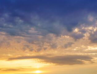 Beautiful colorful evening or morning fluffy clouds in sky. Blue and yellow cloudscape at sunset or sunrise. Nature background.