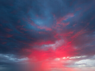 Dramatic sky with storm clouds illuminated by red sunset or sunrise. Vivid colorful cloudscape for nature banner or weather background. Bright sunset or sunrise light.