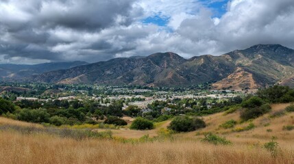 Fototapeta premium Stunning Agoura Hills Landscape: Vibrant Blue Skies Over Grey Mountains and Lush Green Grass in California