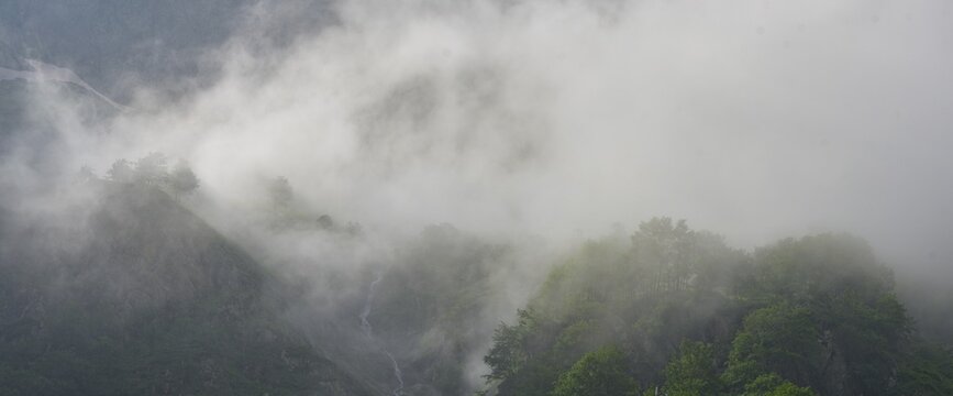 Clouds move over the mountains after a rain shower at Lago della Rovina, Entracque, province of Cuneo, Italy