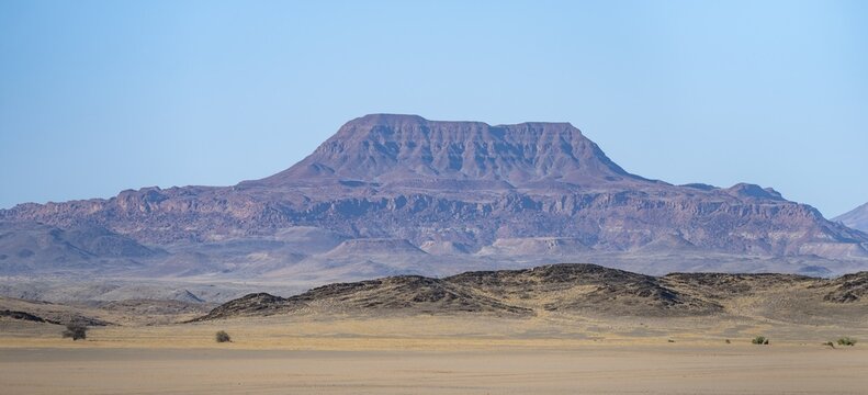 Mountains in a barren desert landscape, silhouettes against the light, Damaraland, Kunene, Namibia