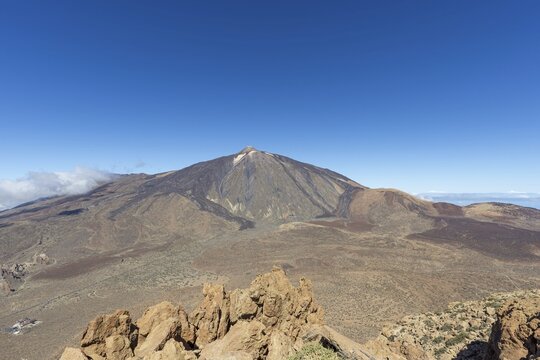 Panorama during the ascent to the Alto de Guajara, 2715m, to the bizarrely shaped rock formations of volcanic rock, Roques de Garc&iacute;a, the visitor centre and the Hotel Parador, behind it the Pico del Teide, 3717m, at sunrise, Teide National Park, Parque Nacional del Teide, Tenerife, Canary Islands, Spain
