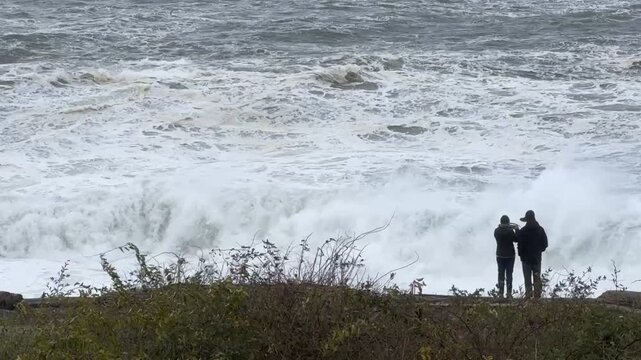 Couple at Oceanside Photographing Turbulent High Tide