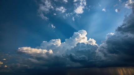 Dramatic Cumulonimbus Clouds Illuminated by Sunbeams with Distant Rain Showers under a Vast Blue Sky