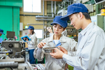 工場で工作機械を操作する作業員グループ