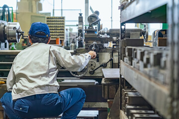 A group of workers operating machine tools in a factory