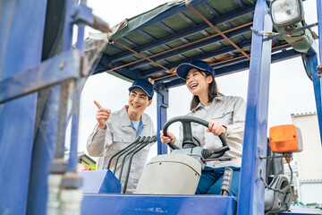 フォークリフトを操作する作業員グループ © metamorworks