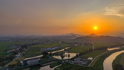 Fototapeta premium Aerial view of winding river and green fields at sunset