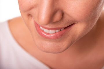 Close-up image of a smiling woman showing her white teeth and natural lips, representing happiness, confidence, and dental health.
