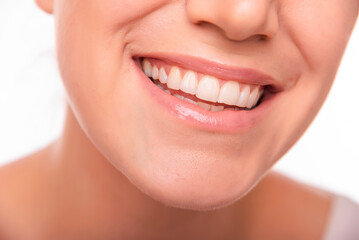 Close-up image of a smiling woman showing her white teeth and natural lips, representing happiness, confidence, and dental health.