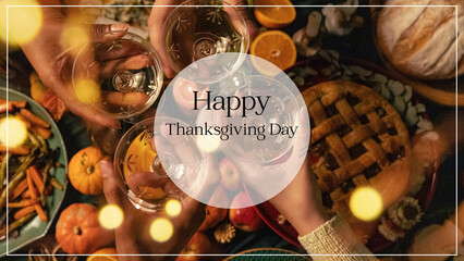 Holiday banner, card  Happy Thanksgiving with text in a translucent white circle on a background of hands raising wine glasses above a festive table with traditional autumn dishes.