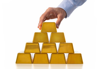 Close up of male hand stacking gold bars isolated on white background