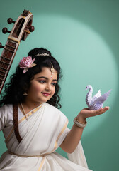 Bal Saraswati child goddess holding paper origami swan with veena and lotus flower, wearing traditional white dress, mint green background