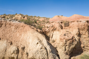 This landscape photo was taken in Europe, Spain, Navarre, in summer. It shows the rocks in the Bardenas Reales, under the Sun.