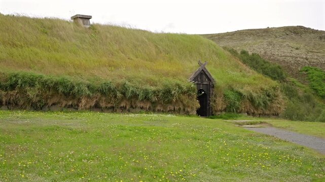 Icelandic traditional turf house with wooden entrance and grassy roof