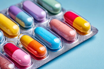 Colorful capsules arranged neatly on a light blue background for medicinal use