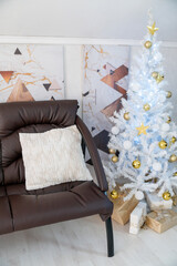 Christmas interior of a bright living room. The attic. A white Christmas tree with a brown sofa. Daytime.