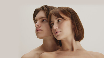 Modern artistic beauty portrait of couple looking aside in quiet balance. Concept of aesthetic mindfulness, identity, visual harmony highlighting gender neutrality and soft awareness.