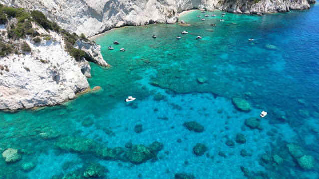 Aerial drone photo of scenic caves and beach in paradise island of Marathonisi in bay of Laganas, visited by small boats a true tourist attraction, Zakithnos island, Ionian, Greece