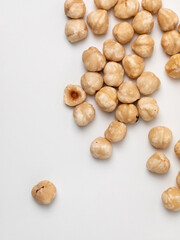 Peeled organic hazelnuts on a white background with copy space