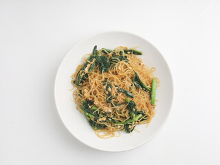 Fried rice noodles and vegetables on wooden background