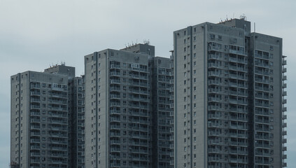 Fototapeta premium Tall Grey Apartment Complex Against Overcast Sky