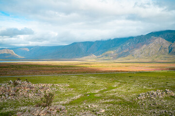 Fototapeta premium The plain at the foot of the mountain is interspersed with red and green.