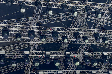 Complex Array of Moving Head Stage Lights, metallic truss system structure for professional event and concert lighting concept, dark background for theatrical design