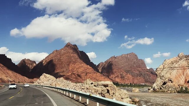 mountainous road leading to tianshan mysterious grand canyon seen from a traveling vehicle, xinjiang, china